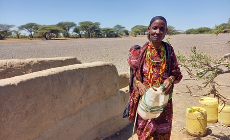 Kenia, Marsabit: Zehn Liter Trinkwasser kann Kame Gonche im Nomadendorf El Boru Magadho für ihre zehnköpfige Familie für einen Tag aus dem Brunnen schöpfen