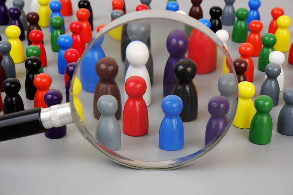 Spielfiguren mit einer Gruppe, die durch eine Lupe betrachtet wird
