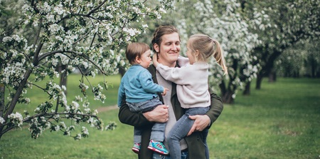 Vater mit zwei Kindern im Arm
